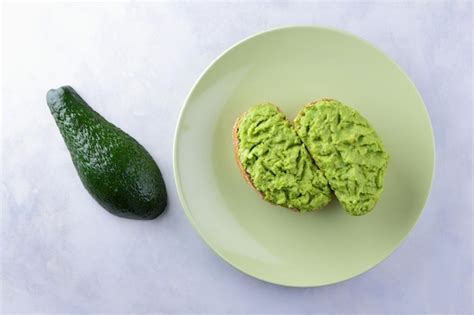 Premium Photo | Two fresh green avocado toasts on a green plate toasts ...