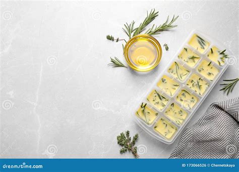 Ice Cube Tray with Herbs Frozen in Oil and Rosemary on Grey Table, Flat ...