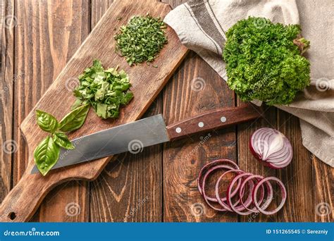 Fresh Aromatic Herbs with Onion and Cutting Board on Wooden Background ...