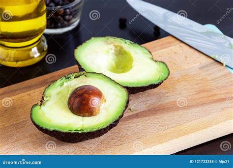 Cut Ripe Avocado Haas on Cutting Board. Dark Wooden Background Stock ...