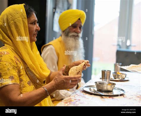 Couple in traditional clothing eating meal at home Stock Photo - Alamy