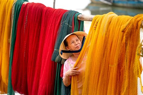 Woman Drying Fishing Nets on a Pole · Free Stock Photo