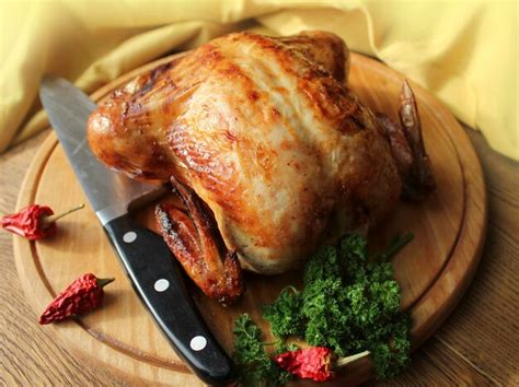 Premium Photo | Whole roasted chicken on cutting board