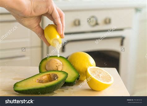 Hand Squeezing Lemon Juice Onto Avocado Stock Photo 791381614 ...