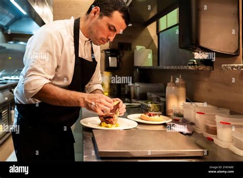 An expert chef plating a gourmet meal with precision in a bustling ...