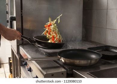 Chef Tossing Vegetables On Frying Pan Stock Photo 1120080104 | Shutterstock