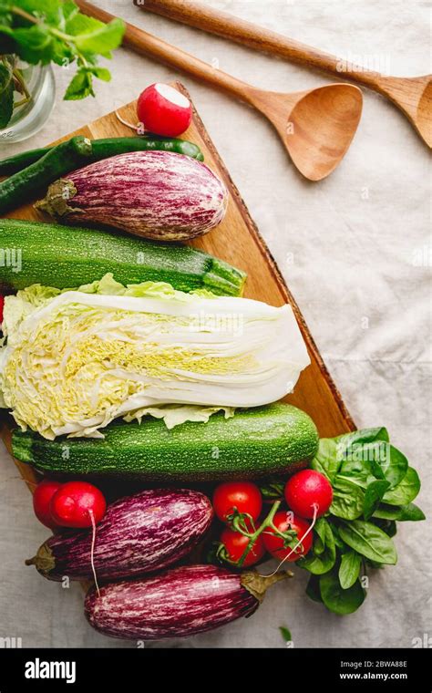 Different vibrant fresh vegetables on a table with wooden kitchen ...