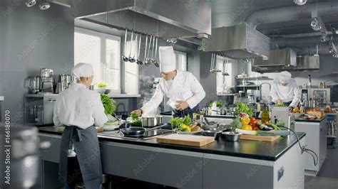 Big and Glamorous Restaurant Busy Kitchen, Chefs and Cooks Working on ...