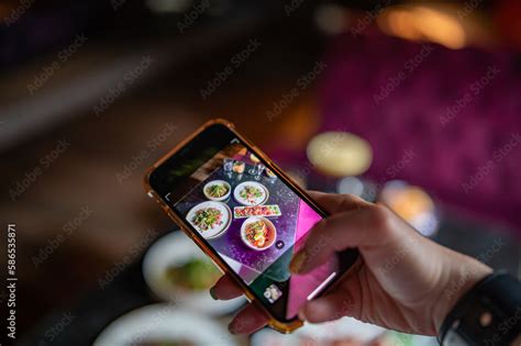 hand with smartphone photographing food at restaurant or cafe Stock ...