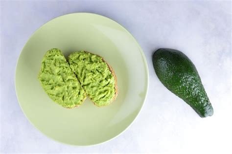 Premium Photo | Two fresh green avocado toasts on a green plate toasts ...