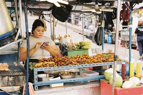 Street food vendor cooking skewers at outdoor market · Free Stock Photo