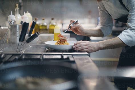 Chef preparing a dish in traditional Italian restaurant kitchen stock photo